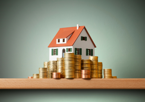 Model of home with coins stacked in front