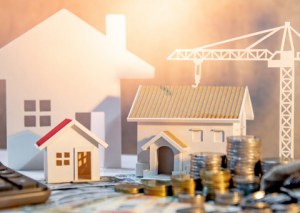 Fake houses and crane with stacks of coins